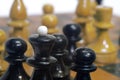 Chess black king surrounded by his pawns on the background of ot Royalty Free Stock Photo