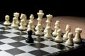 Chess black pawn stands opposite white chess opponent. Symbol of leadership and confrontation. Horizontal frame