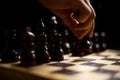 Chess, black`s first move, a man`s hand holding a black pawn Royalty Free Stock Photo