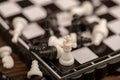 A chess board and black and white chess pieces on a wooden table, close-up, selective focus Royalty Free Stock Photo