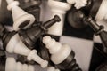 A chess board and black and white chess pieces on a wooden table, close-up, selective focus Royalty Free Stock Photo