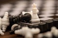 A chess board and black and white chess pieces on a wooden table, close-up, selective focus Royalty Free Stock Photo