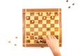 Chess board with chess pieces and a kid hand. Royalty Free Stock Photo