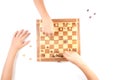 Chess board with chess pieces and a kid hand. Royalty Free Stock Photo