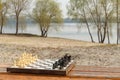 Chess board with chess pieces on wooden bench with river embankment background Royalty Free Stock Photo