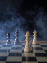 Chess board game concept of battle, war and strategy. Chess figures on a dark background with smoke and fog. Selective focus Royalty Free Stock Photo