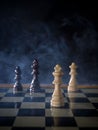 Chess board game concept of battle, war and strategy. Chess figures on a dark background with smoke and fog. Selective focus Royalty Free Stock Photo