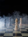 Chess board game concept of battle, war and strategy. Chess figures on a dark background with smoke and fog. Selective focus Royalty Free Stock Photo