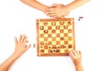 Chess board with chess pieces and a playing kids hand. Royalty Free Stock Photo