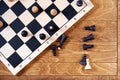 Chess board with scattered figures during the game on the wooden table Royalty Free Stock Photo