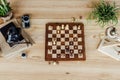 Chess board set with old vintage cameras and books on wooden table