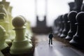 Chess concept of business and strategy ideas. Silhouette of a man standing in the middle of the road with giant chess figures and