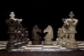Chess faceoff of both knight horses on top of a chess board in front of a dark background Royalty Free Stock Photo