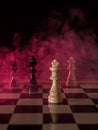 Chess figures on a dark background with red smoke and fog. Chess board game concept of competition and strategy. Selective focus Royalty Free Stock Photo