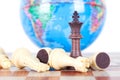 Chess figures in front of the globe Royalty Free Stock Photo
