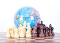 Chess figures in front of the globe Royalty Free Stock Photo