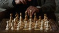 Chess game board closeup. Senior man hand moving figure in strategy game. Royalty Free Stock Photo