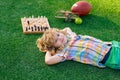 Chess game for children. Kid relax in park, laying on grass, daydreaming. Kid playing chess. Games and activities for