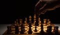 chess game chess figures on an old wooden table, black background copy space, the hand of a businessman moving chess figure, strat Royalty Free Stock Photo