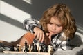 Chess game with kids at home. Chess for intelligent kid. Child genius, smart pupil playing logic board game. Clever Royalty Free Stock Photo