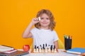 Chess for intelligent kid. Child genius, smart pupil playing logic board game. Clever school boy thinking about chess Royalty Free Stock Photo