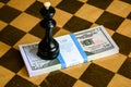 Chess king and dollar bills stack on chessboard