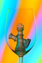 Chess king and queen in a wine glass against abstract background Royalty Free Stock Photo