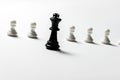 Chess king is standing against white pawns. Symbol of leadership and confrontation. Horizontal frame Royalty Free Stock Photo