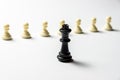 Chess king is standing against white pawns. Symbol of leadership and confrontation. Horizontal frame Royalty Free Stock Photo