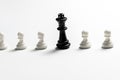 Chess king is standing against white pawns. Symbol of leadership and confrontation. Horizontal frame Royalty Free Stock Photo