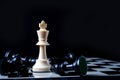 Chess king standing wins the game of chess setup on dark background. Chess concept save the king and save the strategy, game over Royalty Free Stock Photo