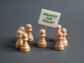 Chess pawn protester holding a sign banner with the message PROTECT OUR PLANET Royalty Free Stock Photo