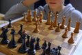 Chess piece across chess board and person thinking of a next move close-up. Playing chess. Strategy, planning concept