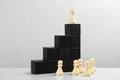Chess piece on top of black stairs against background. Career promotion concept