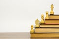 Chess pieces and books on a wooden table. Royalty Free Stock Photo