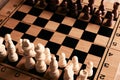 Chess pieces and chessboard on a wooden table Royalty Free Stock Photo