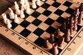 Chess pieces and chessboard on a wooden table Royalty Free Stock Photo