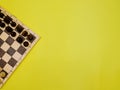 Chess pieces on a chessboard on a yellow background. Black and white figures of different designations Royalty Free Stock Photo