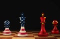 Chess pieces in color of national flags on board against black background. Trade war Royalty Free Stock Photo