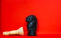 Chess pieces knights facing each other for a standoff with blurred isolated on red background. Confrontation of chess pieces.Chess Royalty Free Stock Photo