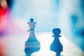 Chess pieces pawn and queen queen in a bright haze. Business-the concept Royalty Free Stock Photo