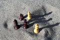 Chess pieces on the sand by the river