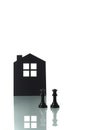 Chess pieces with silhouette of a house in the background Royalty Free Stock Photo