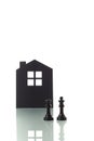 Chess pieces with silhouette of a house in the background Royalty Free Stock Photo