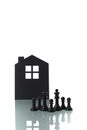 Chess pieces with silhouette of a house in the background Royalty Free Stock Photo