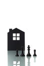 Chess pieces with silhouette of a house in the background Royalty Free Stock Photo