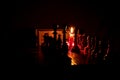 Chess pieces stand on a chessboard and clock and next to a burning candle in the dark, playing Royalty Free Stock Photo