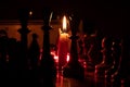Chess pieces stand on a chessboard and clock and next to a burning candle in the dark, playing Royalty Free Stock Photo