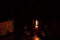 Chess pieces stand on a chessboard and clock and next to a burning candle in the dark, playing Royalty Free Stock Photo