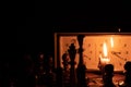 Chess pieces stand on a chessboard and clock and next to a burning candle in the dark, playing Royalty Free Stock Photo